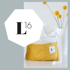 Logo von Loggia16 mit einem Leinesack in Goldgelb und einer Vase mit Blumen im Hintergrund